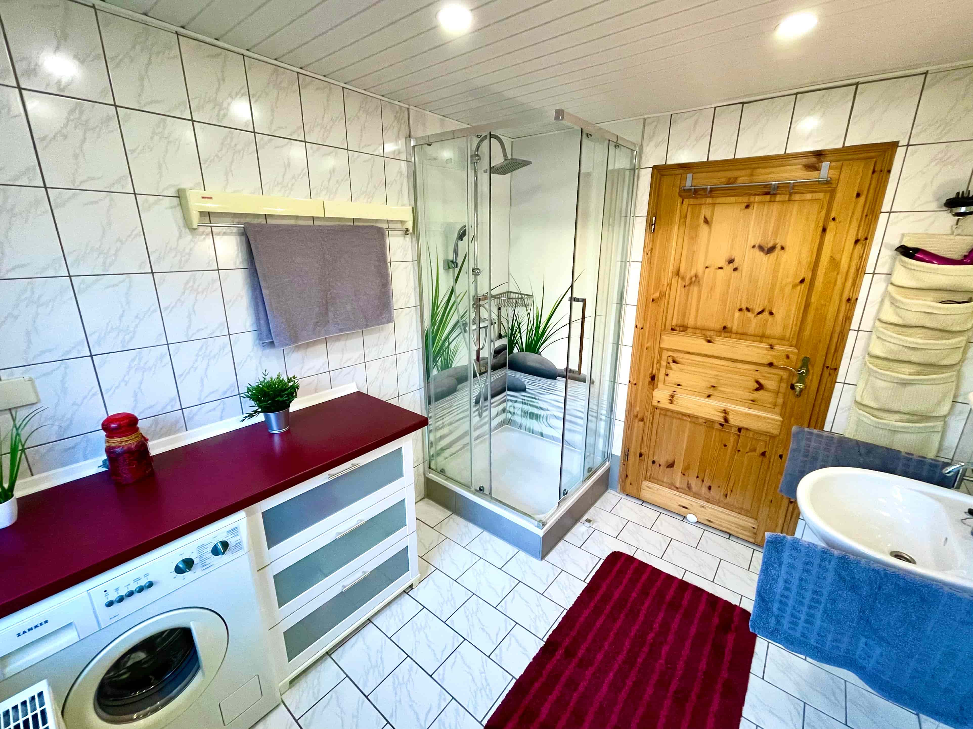 Badezimmer mit Dusche und Waschmaschine